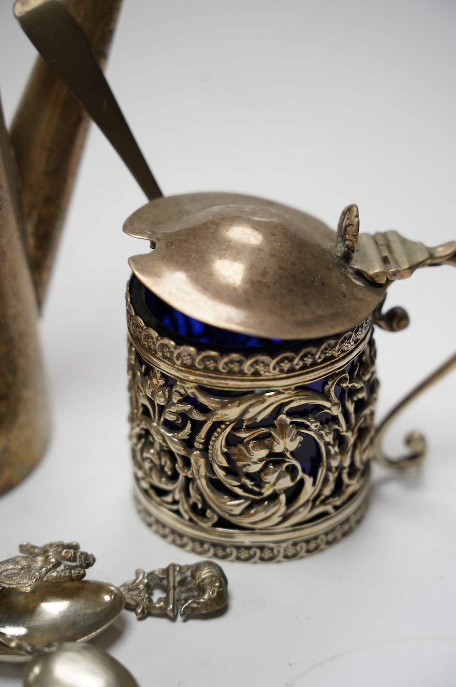 Small silver including a late Victorian pierced silver mustard pot, a small cream jug and oval trinket box, together with five metal spoons and a plated hot water jug. Condition - poor to fair